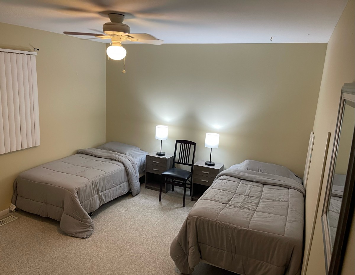 A cozy bedroom with twin beds and softly lit nightstands.