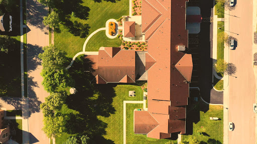 Aerial view of a beautifully landscaped home with lush green surroundings.