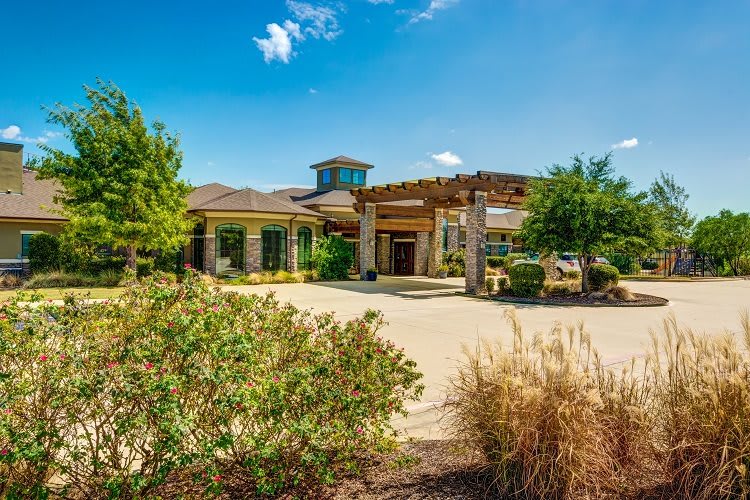 A beautiful residential home with well-maintained landscaping under a clear blue sky.