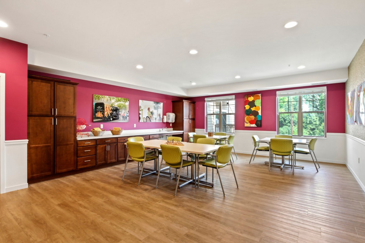 A modern dining area with colorful walls, contemporary furniture, and artwork displayed on the walls.