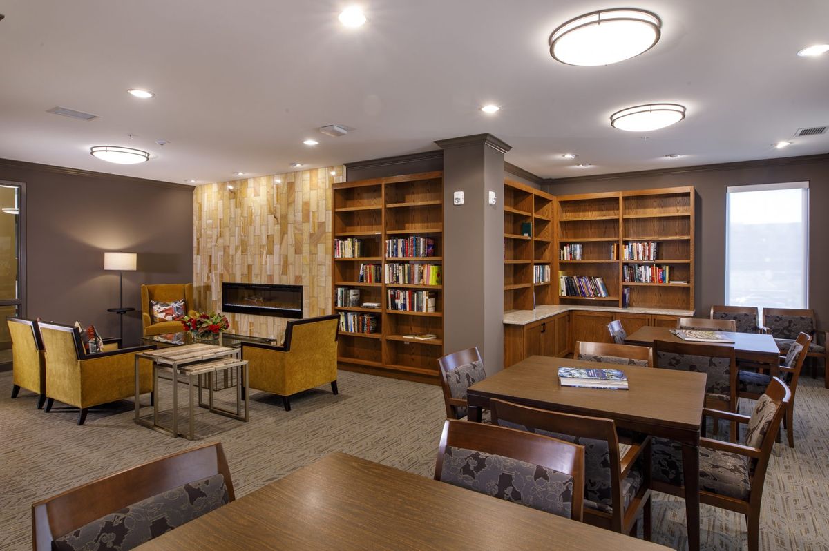 A cozy library reading area with bookshelves and comfortable seating.