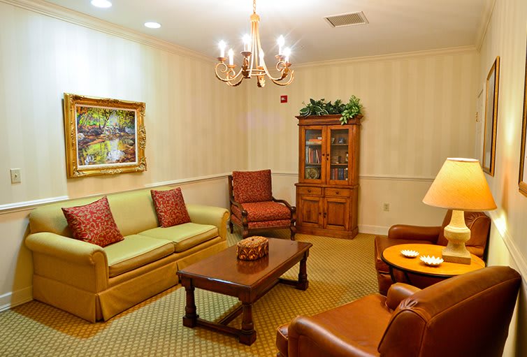 A cozy living room with comfortable seating, a chandelier, and tasteful decor.