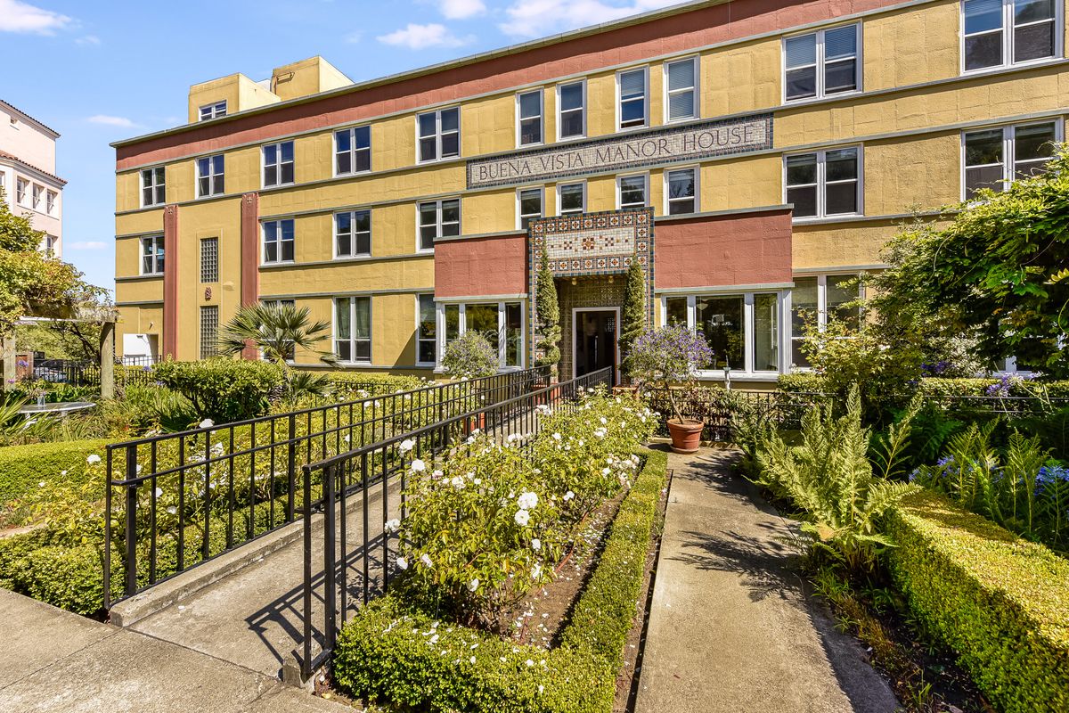 A residential building with a garden pathway leading to the entrance.