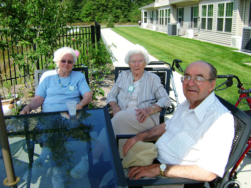 A group of three elderly individuals enjoying a sunny day outdoors.