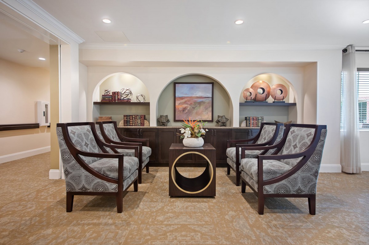 Elegant living room with stylish chairs, a central table, and decorative artwork on display.