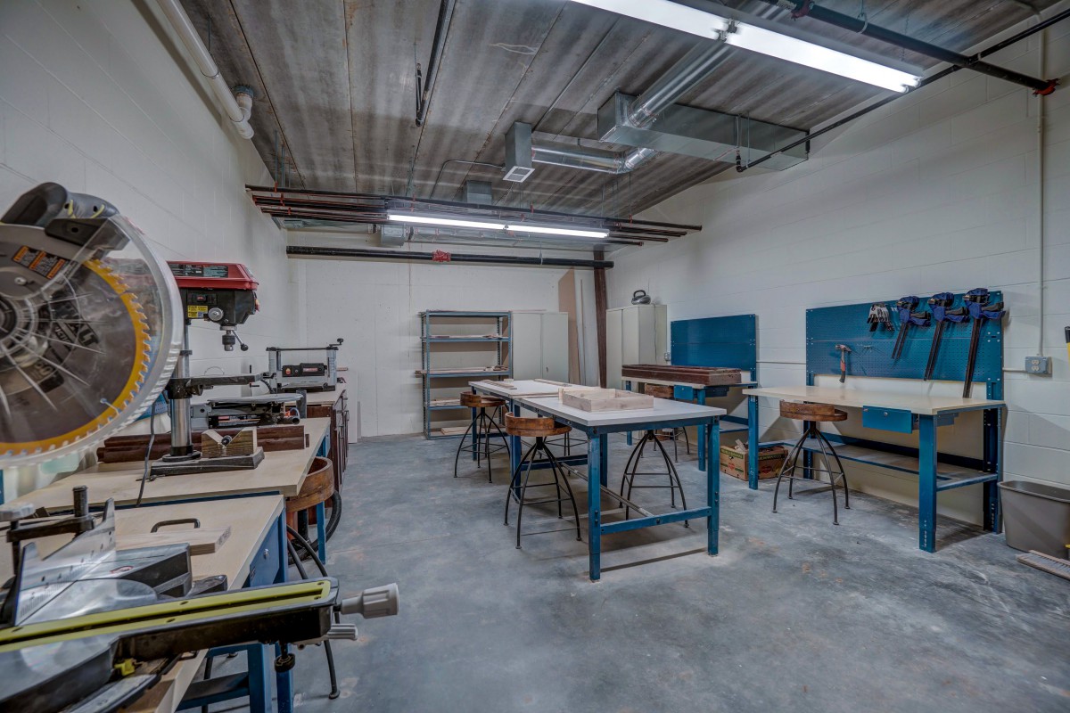 A spacious workshop with various tools and workbenches, ready for woodworking projects.