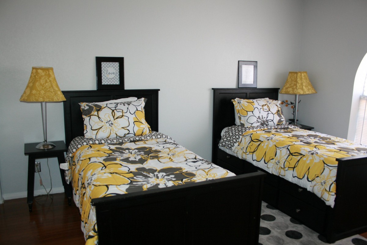 A cozy bedroom with twin beds featuring vibrant floral bedding.