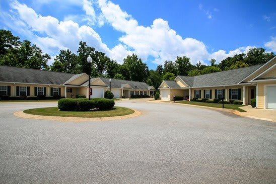 A peaceful suburban neighborhood with multiple houses and a clear blue sky.