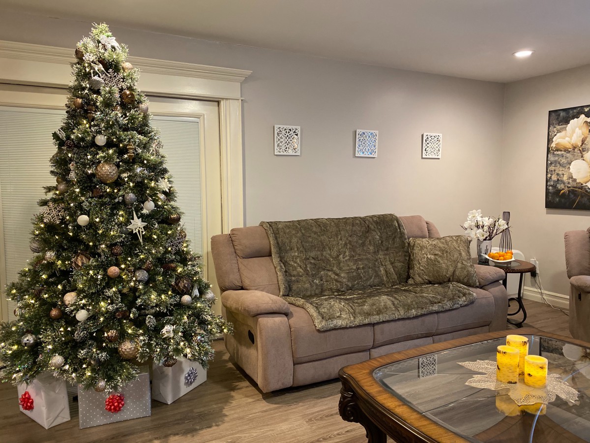 A cozy living room decorated for the holidays with a Christmas tree and presents.