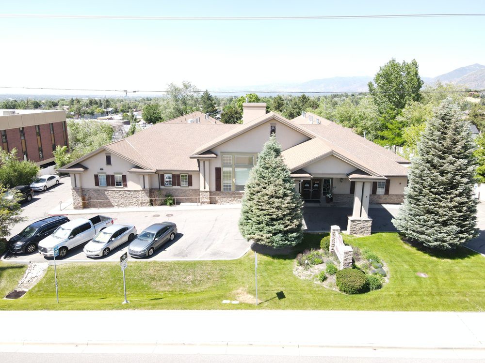 A suburban house with a well-maintained lawn and a small parking area.