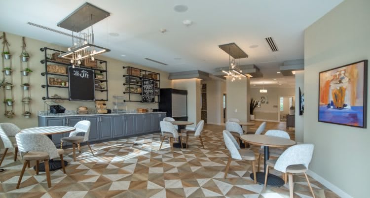 A modern cafe interior with stylish furniture and geometric flooring.