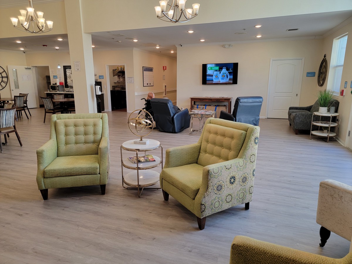 A cozy lounge area with comfortable seating and a TV on the wall.