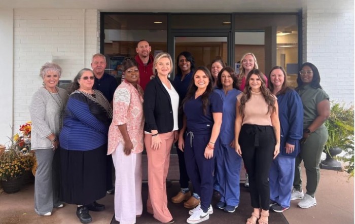 A group of medical staff posing together in front of a building.