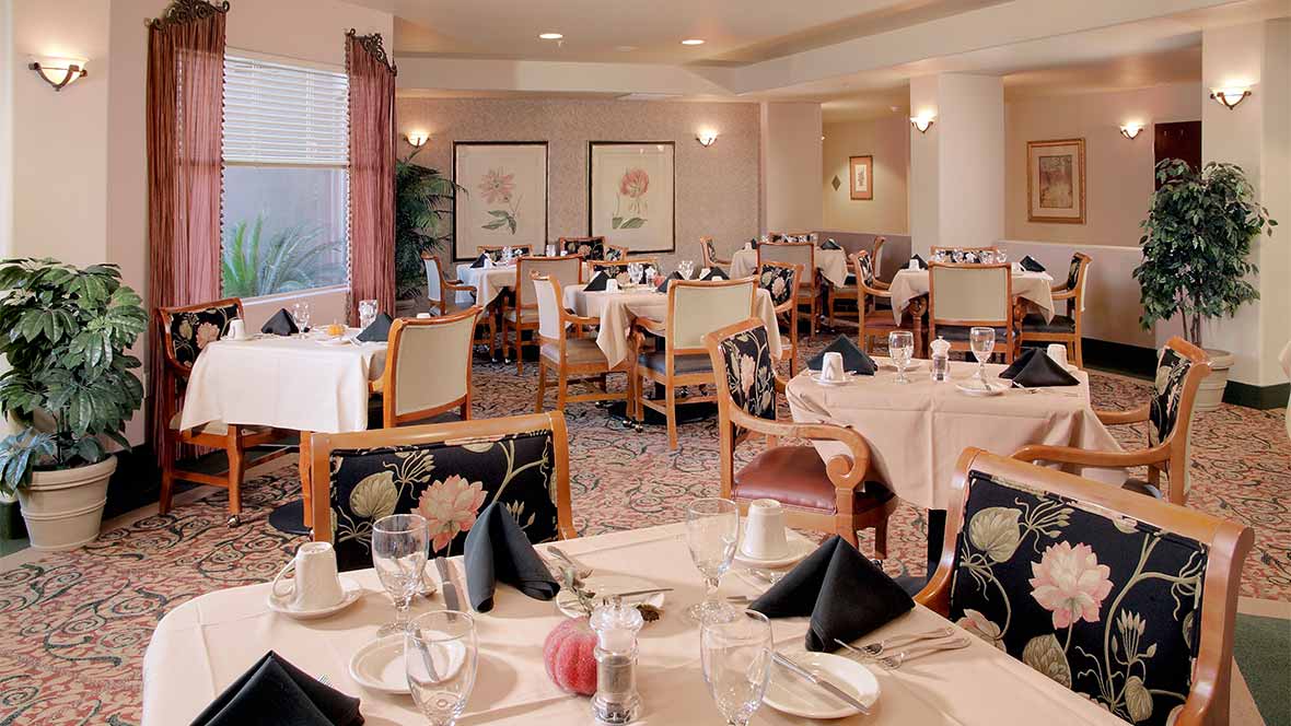 An elegant restaurant dining room with neatly arranged tables and chairs.