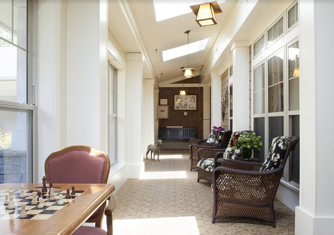 A sunlit hallway with comfortable seating and large windows.