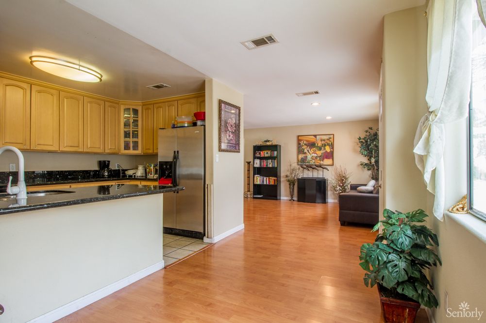 A cozy open floor plan featuring a kitchen and living room with wood flooring and stylish decor.