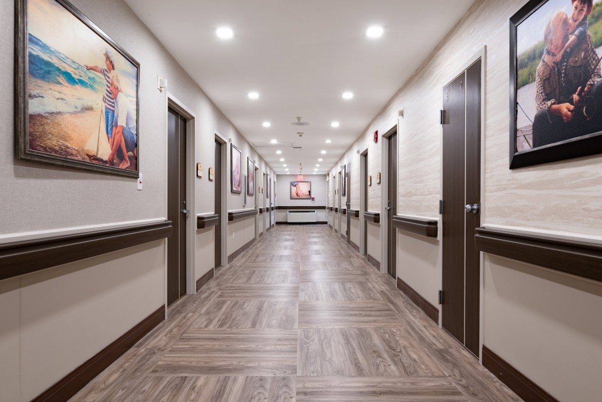 A modern, well-lit hallway featuring several doors and artwork on the walls.