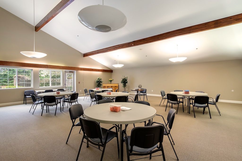 An empty conference room with round tables and chairs arranged for a meeting.