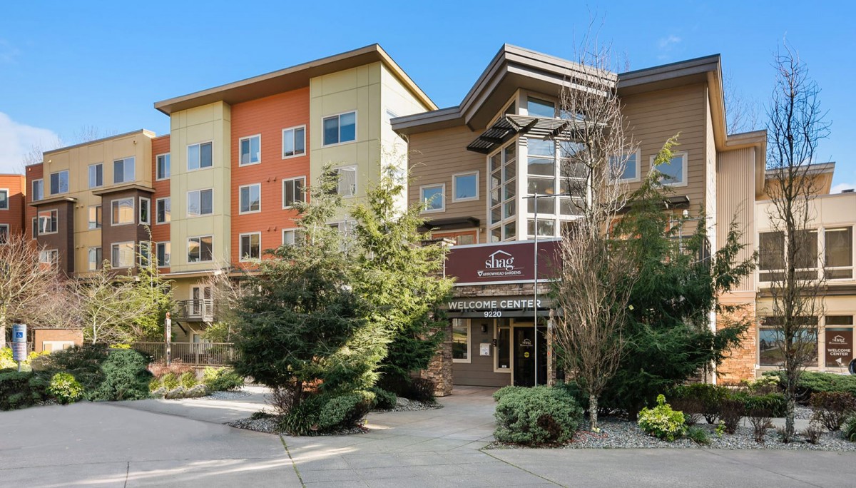 A modern residential building with a landscaped entrance and colorful exterior.
