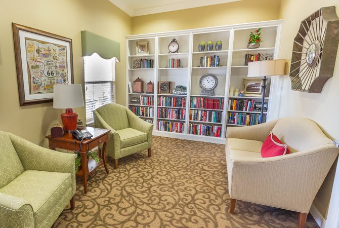 A cozy living room with bookshelves and comfortable seating.