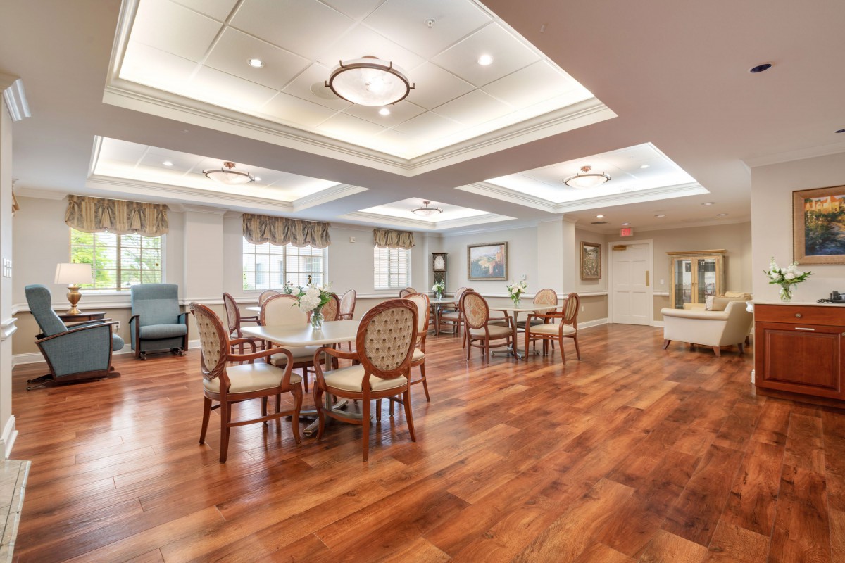 Elegant dining area with wooden flooring and classic furniture.
