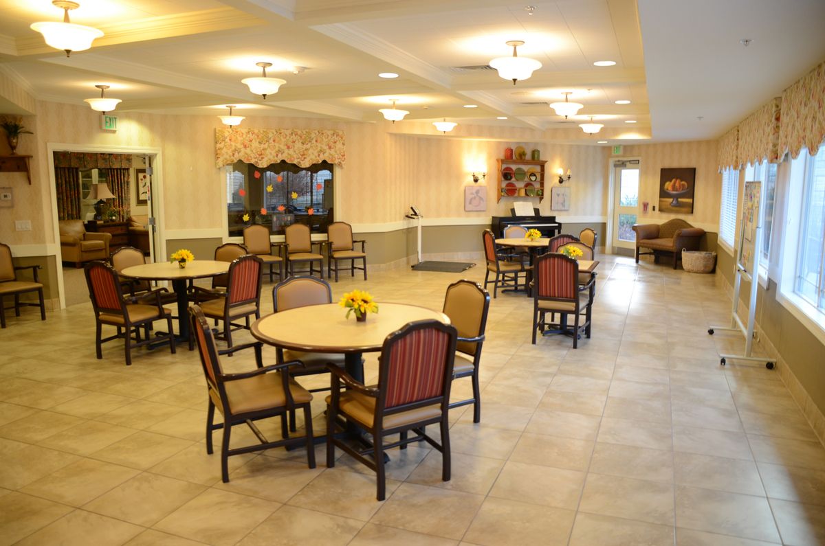 A well-lit dining area with round tables and chairs arranged neatly.