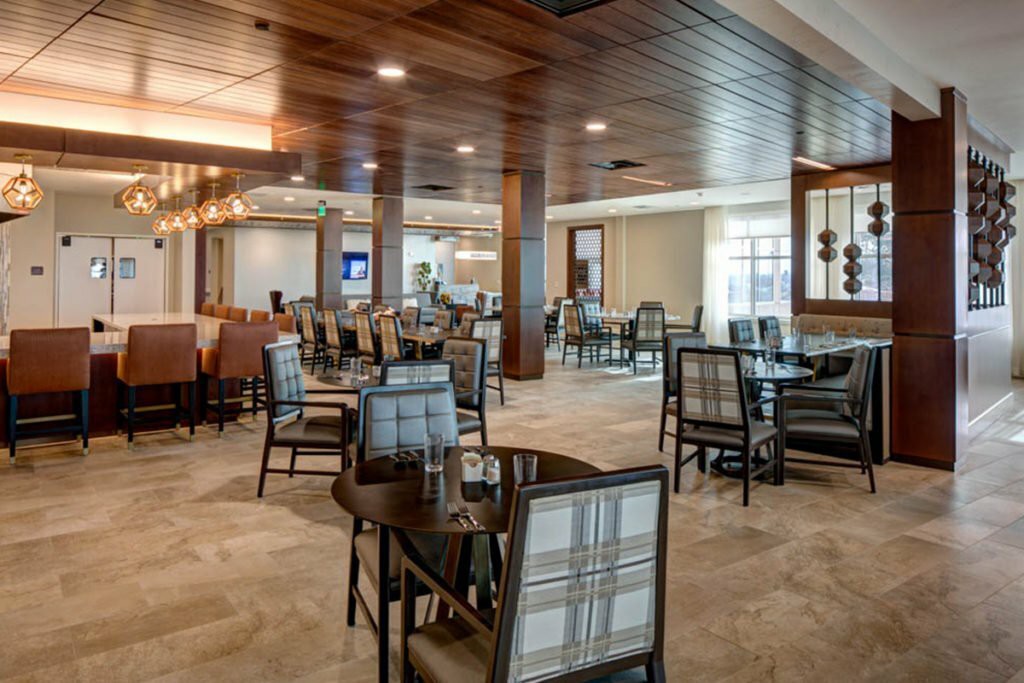 A spacious and modern restaurant dining area with neatly arranged tables and chairs.