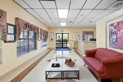 A spacious and welcoming lobby area featuring a comfortable sofa, coffee table, and large windows.