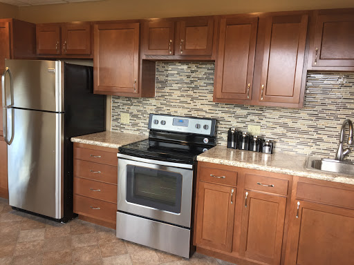 A modern kitchen featuring wooden cabinets, stainless steel appliances, and a stylish tile backsplash.