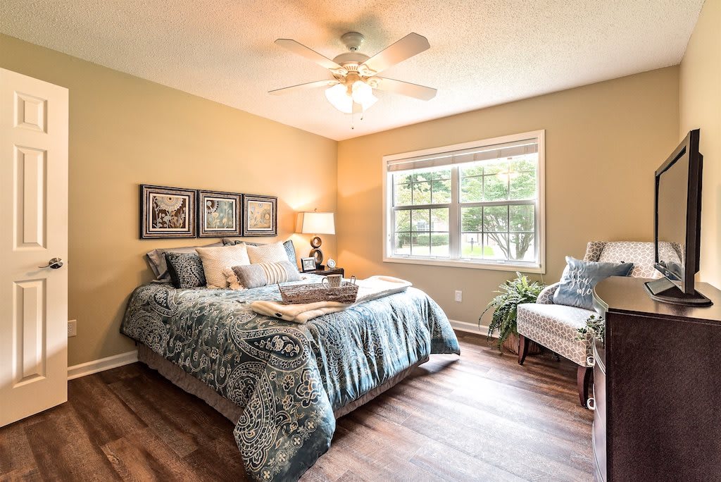A cozy bedroom with elegant decor, featuring a comfortable bed, artwork on the walls, and soft lighting.