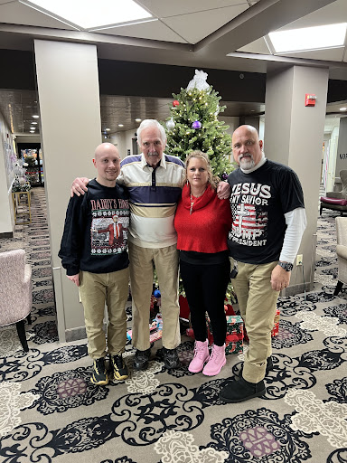 A joyful family gathering in front of a Christmas tree, celebrating the holiday season together.