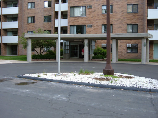 The entrance of an apartment building with landscaped surroundings.