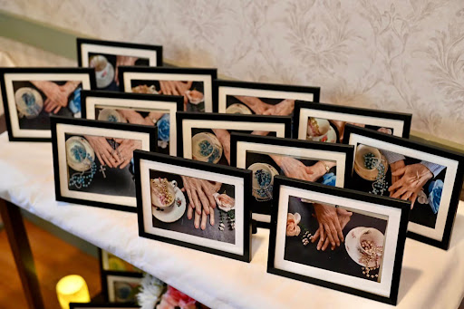 A showcase of beautifully framed photos capturing moments involving hands, elegantly displayed at an event.