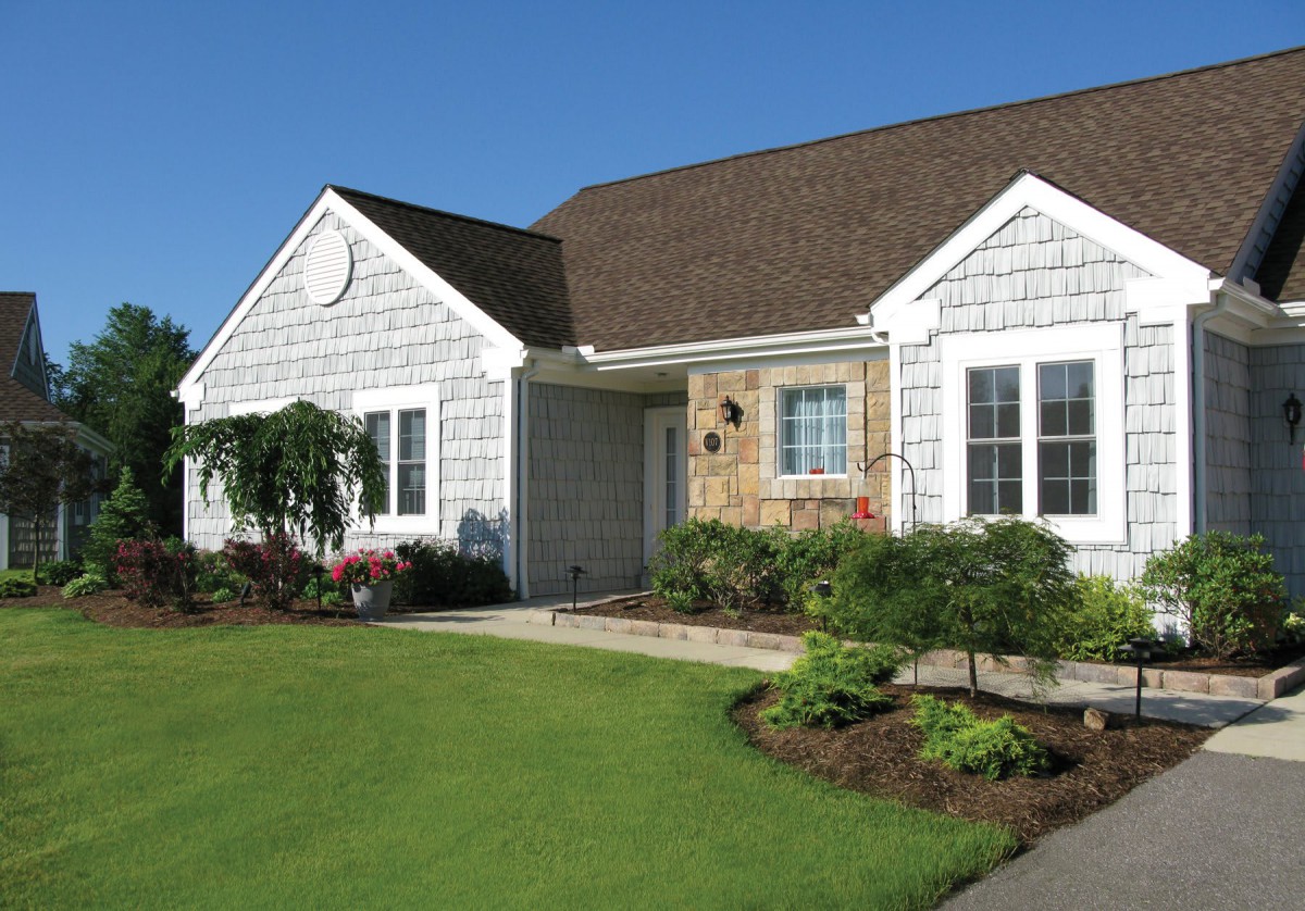 A well-maintained suburban house with a manicured lawn and landscaping.