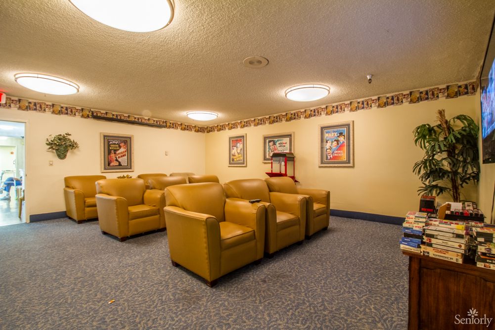 A comfortable seating area with multiple chairs, framed art on the walls, and soft lighting.