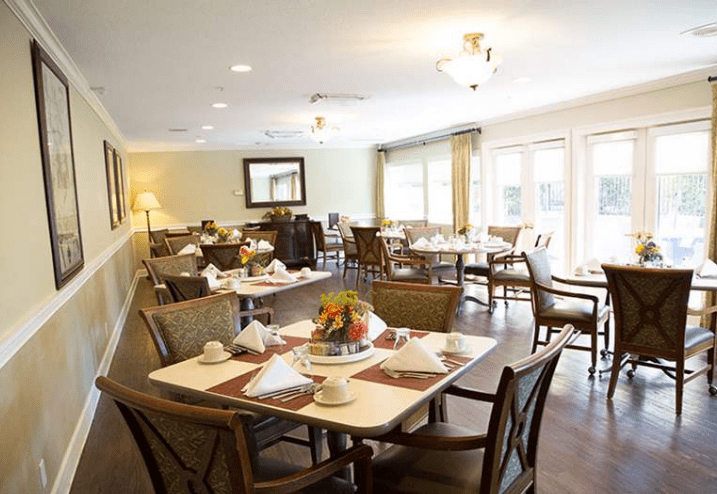A well-lit dining area with neatly set tables and comfortable seating.