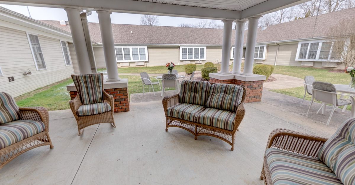 A cozy patio with wicker furniture and cushions, providing a comfortable outdoor seating area.