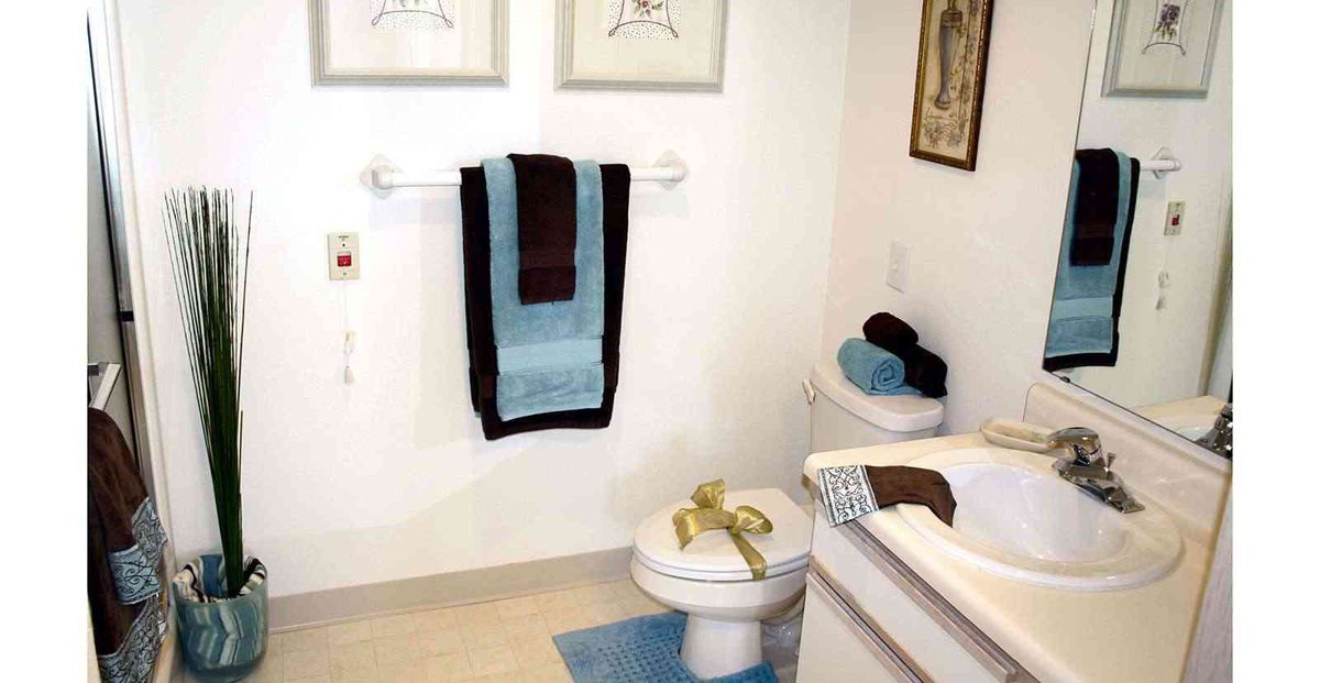 A neatly arranged bathroom with stylish towels and decor.