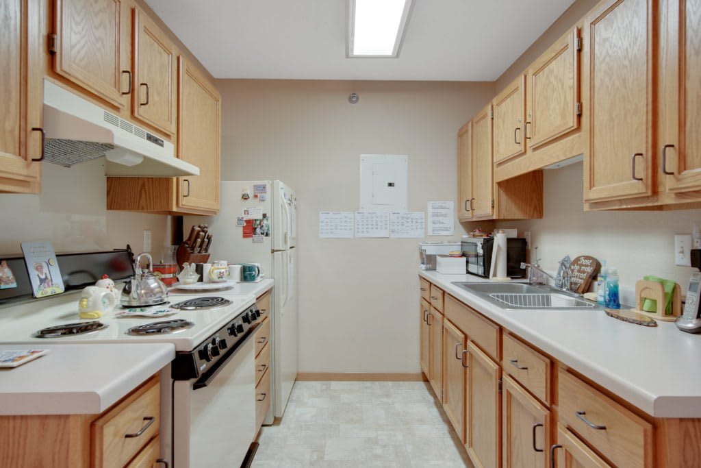 A traditional kitchen setup with wooden cabinets and essential appliances.