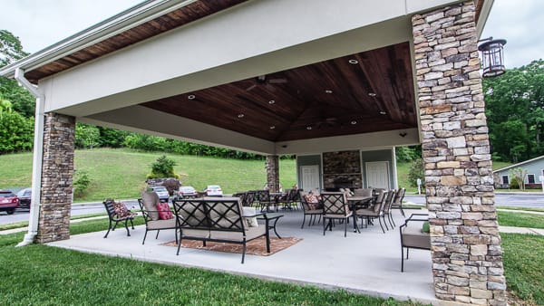 A spacious covered patio with elegant outdoor furniture, perfect for relaxation and gatherings.