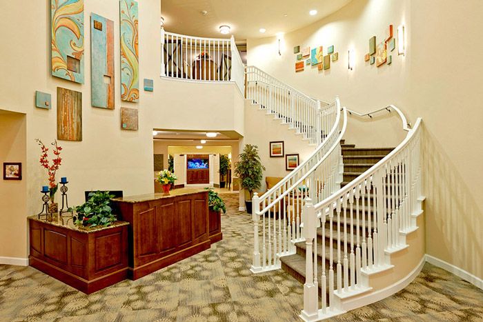 An elegant hotel lobby featuring a grand staircase and welcoming reception area.