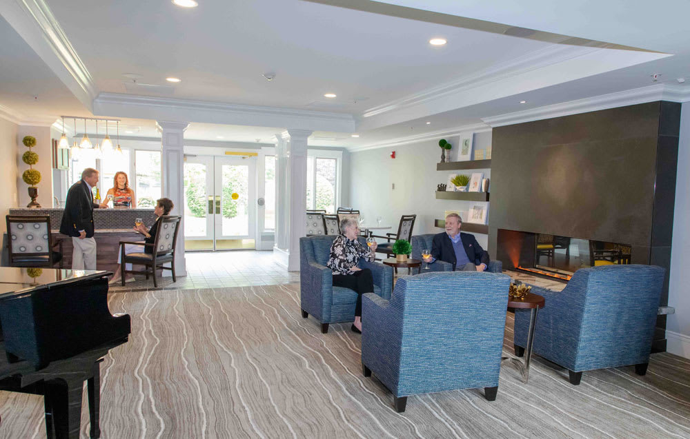 A modern and comfortable living room with people seated, featuring stylish furniture and decor.
