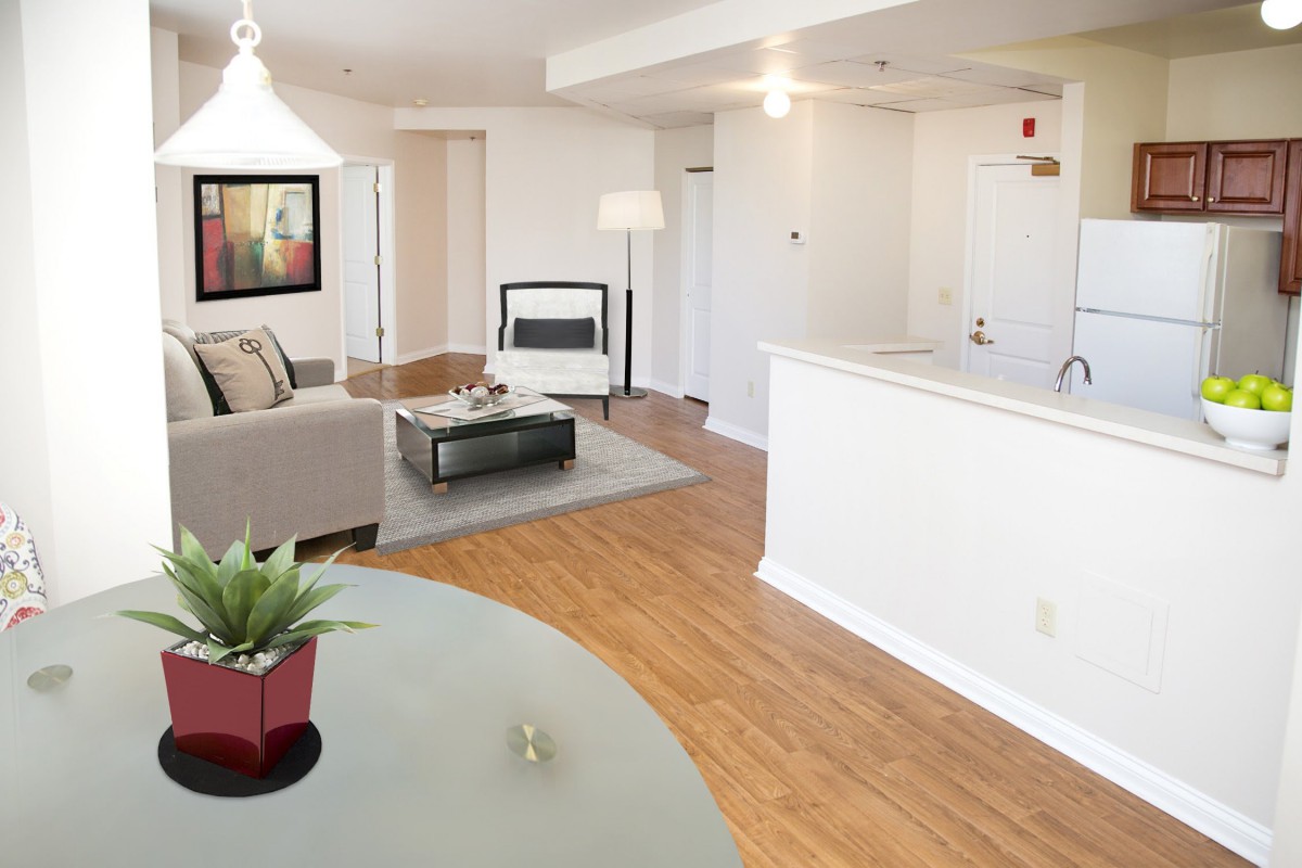 A modern, minimalist living room with an open layout and wood flooring.