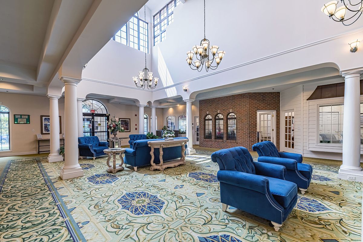 A luxurious and spacious lobby with elegant blue furniture and chandeliers.