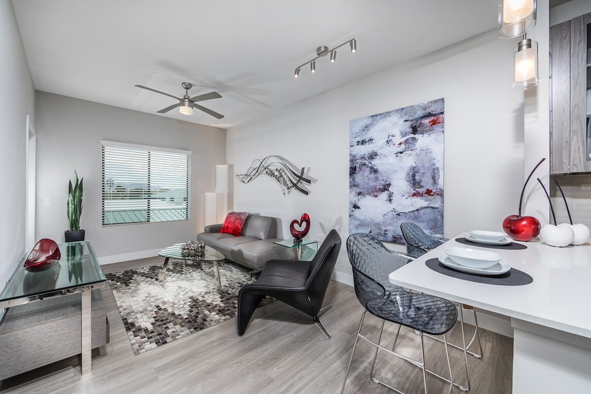 A modern living room with contemporary furniture and minimalist decor, featuring a stylish dining area and accent wall art.
