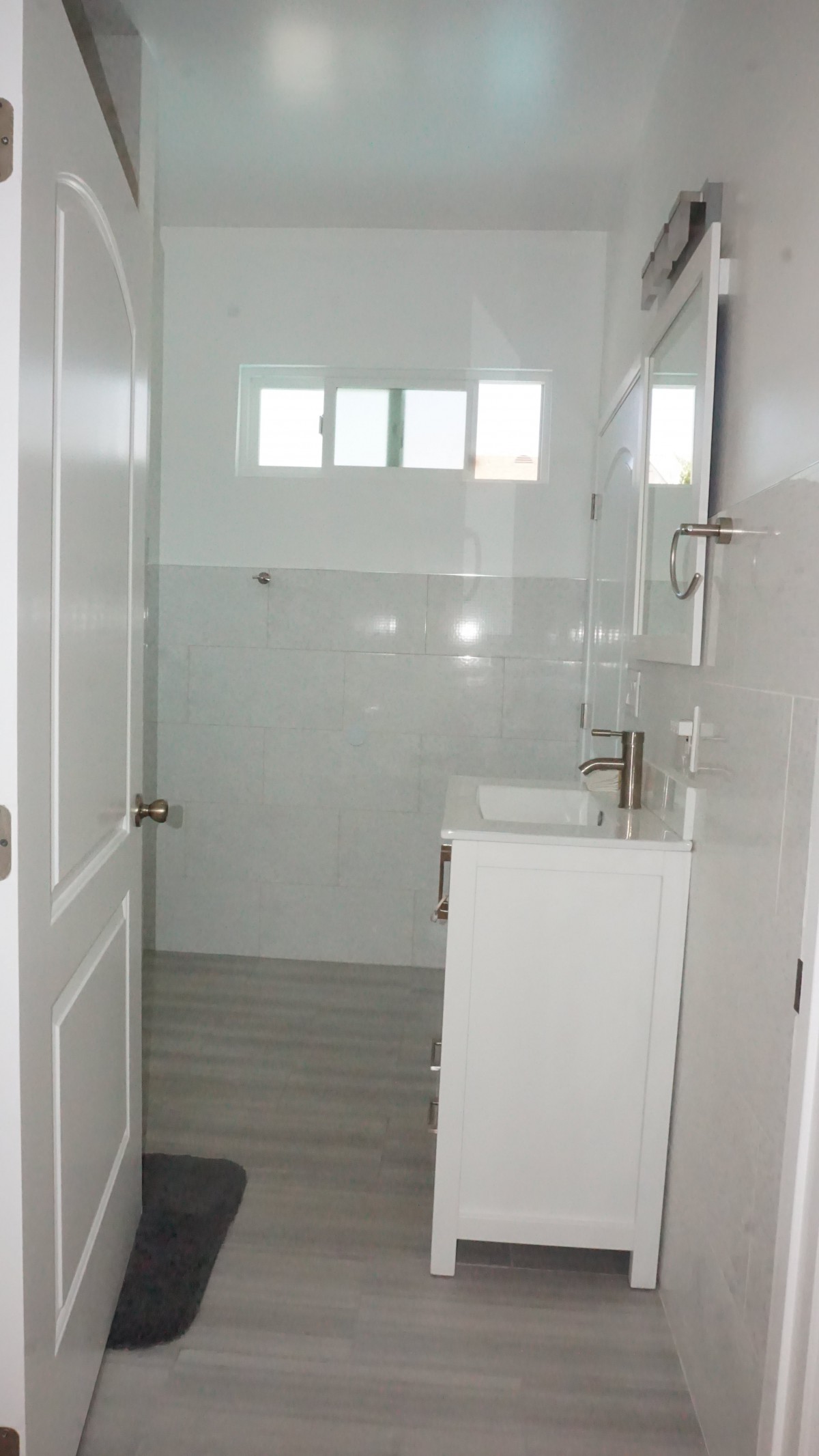A modern and clean white bathroom interior with a sink and mirror.