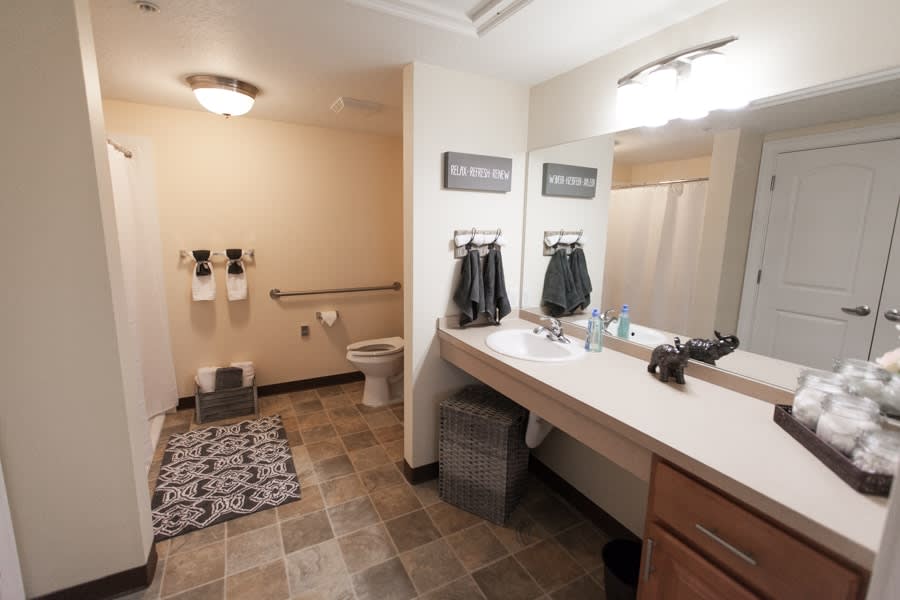 A modern bathroom interior with a sink, mirror, and toilet.