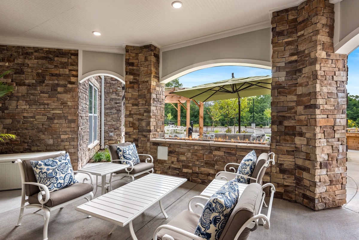 A cozy outdoor patio with comfortable seating and a view of the garden.