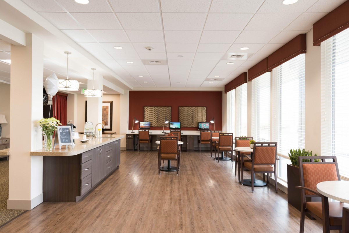 A modern office reception area with seating and computer stations.