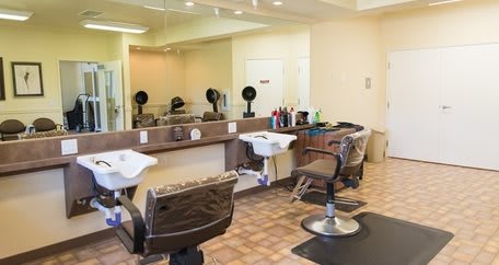 Interior of a modern barber shop with chairs, mirrors, and sinks.